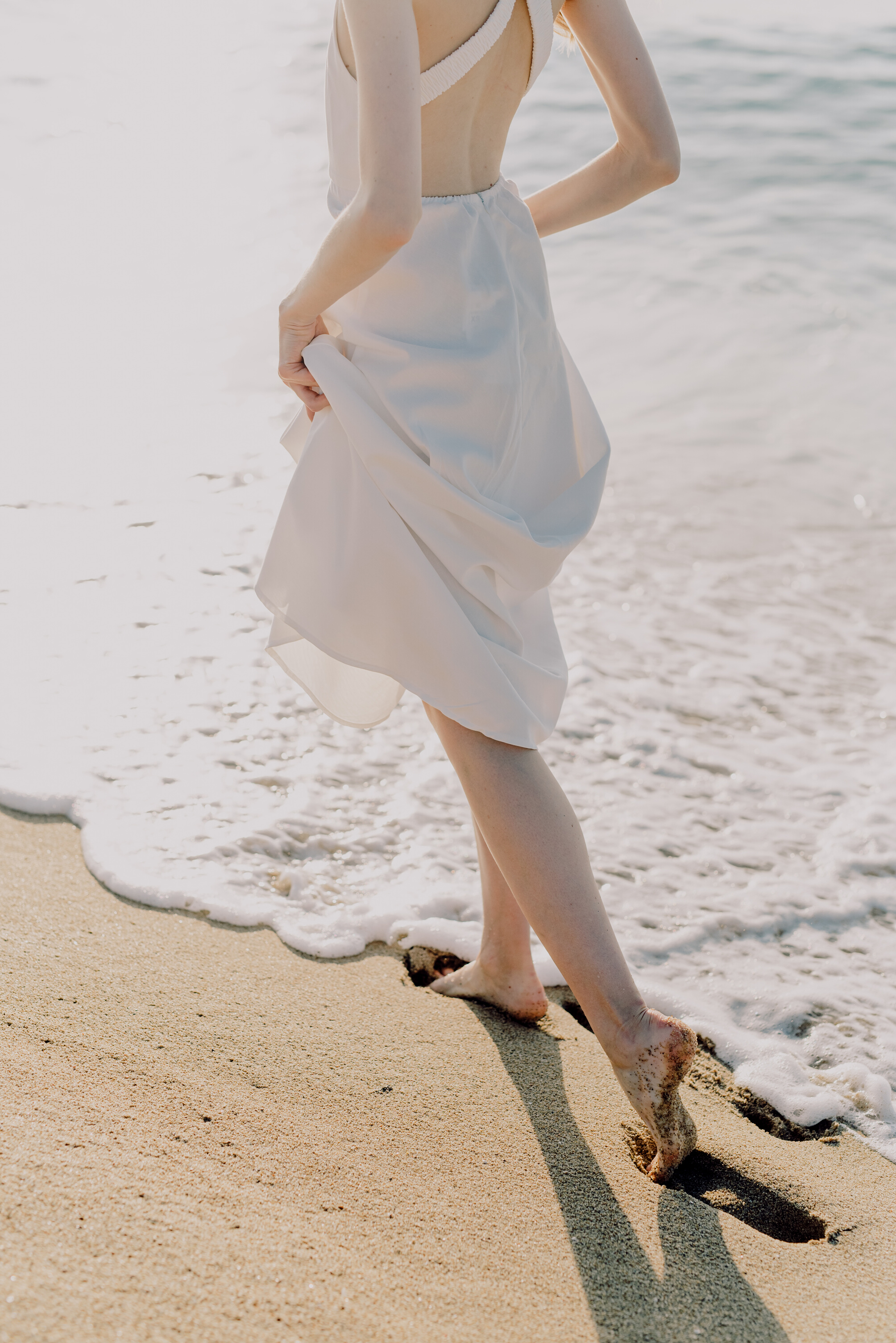 Woman in White Dress Walking on Beach